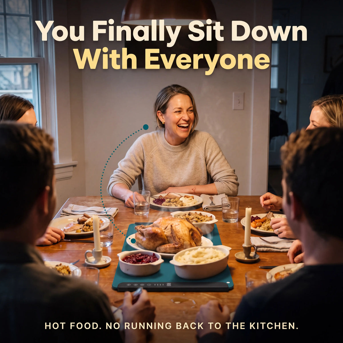 The host seated and laughing at Thanksgiving dinner while the mat keeps the food warm
